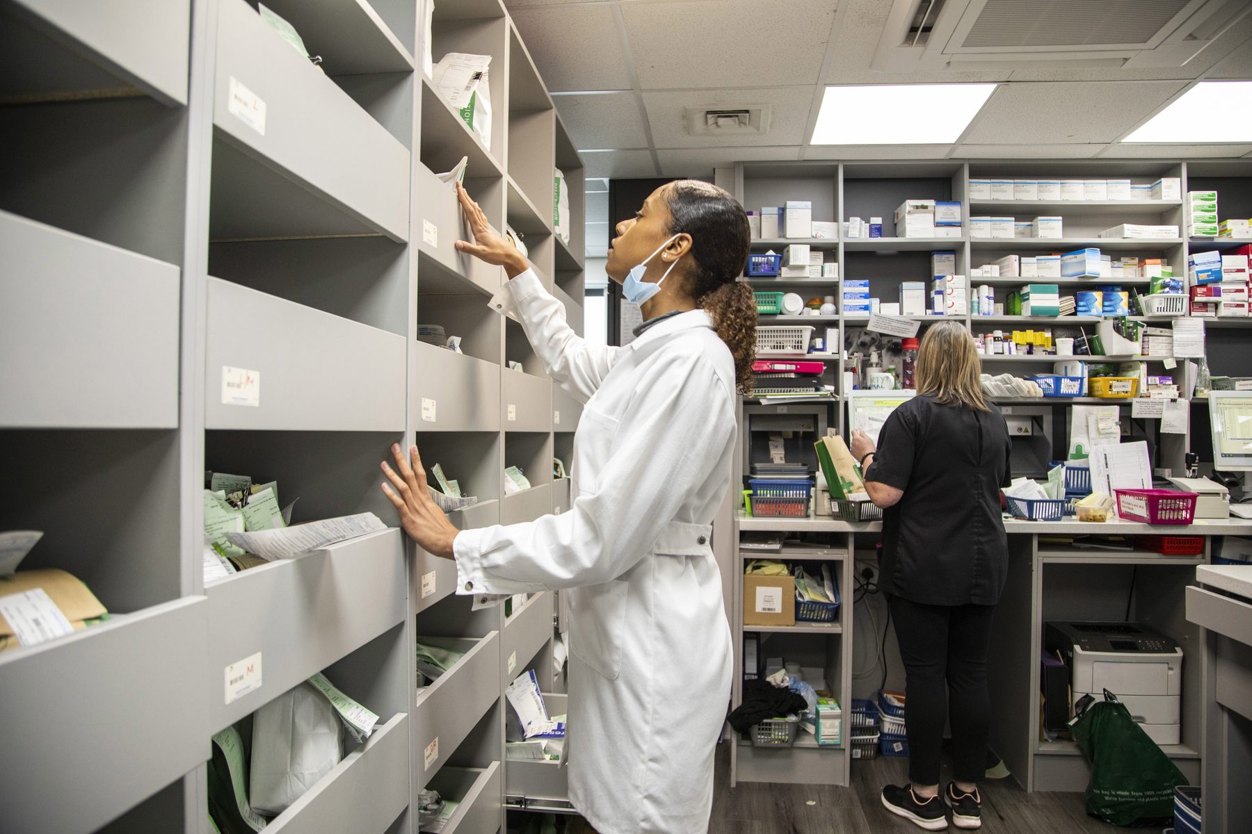Pharmacists organizing medication in a pharmacy storage room